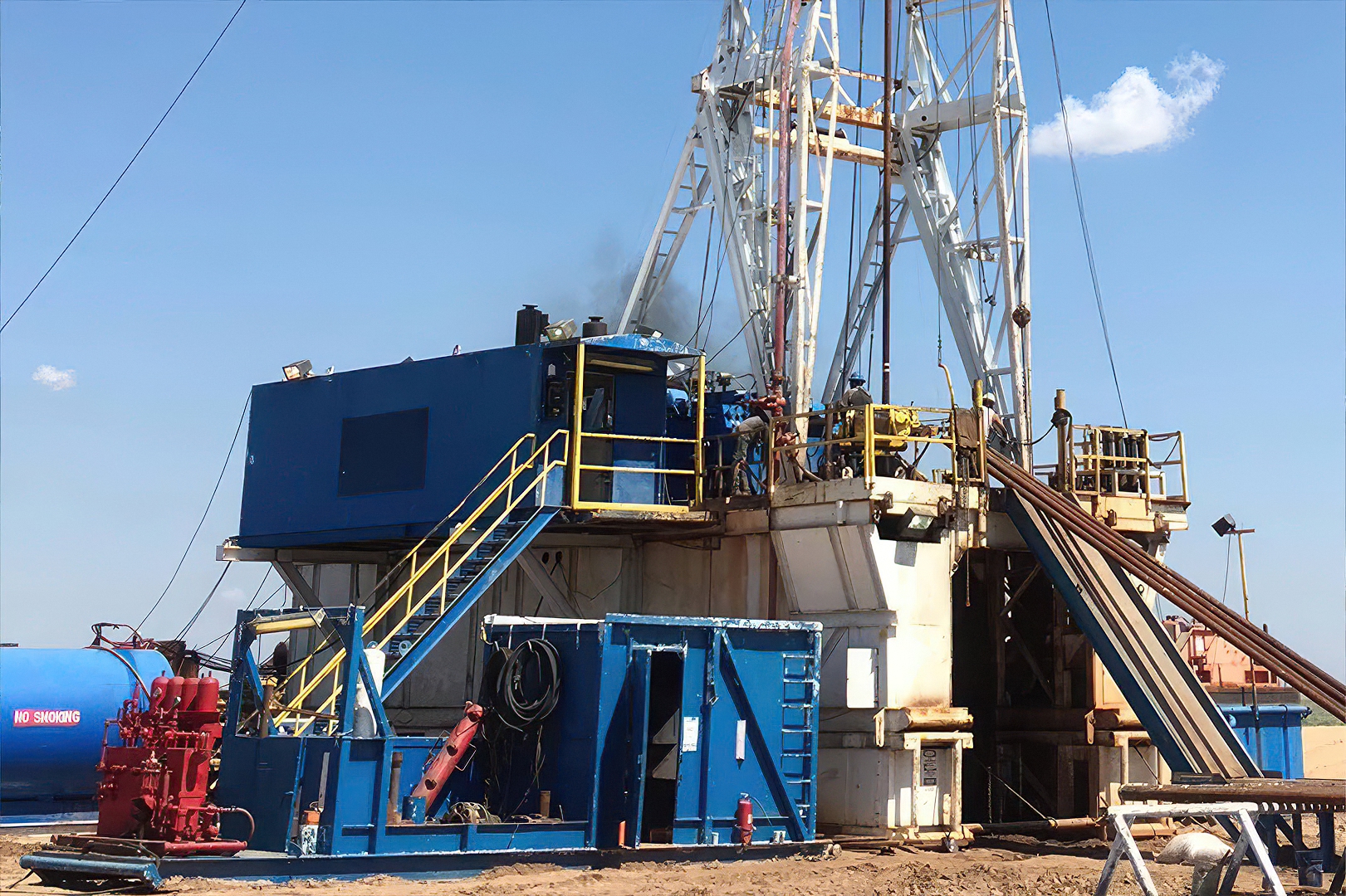 base of oil rig with men working on the rig
